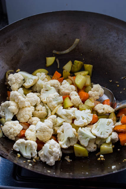 cauliflower, potatoes, and carrots in a wok