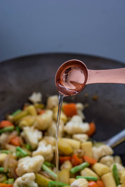 pouring water in a wok from a teaspoon