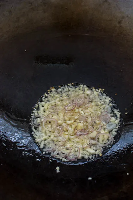 minced garlic and sliced shallots in a wok