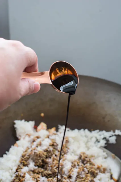 pouring soy sauce over rice