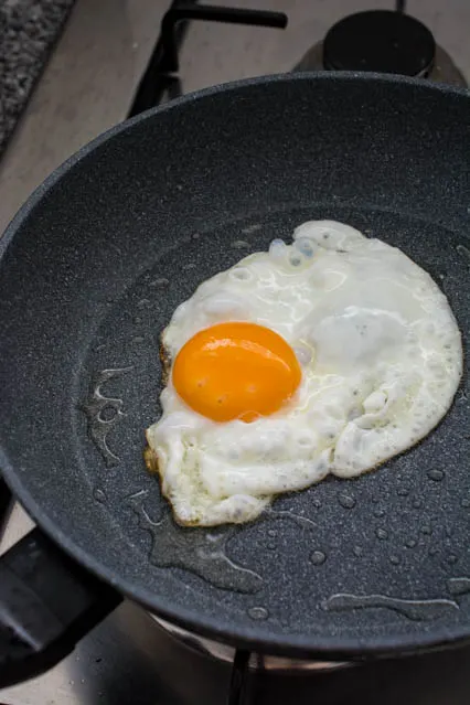 frying an egg for indonesian nasi goreng