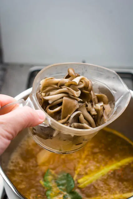 adding mushrooms to tom yum soup