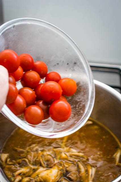 adding cherry tomatoes to tom yum soup