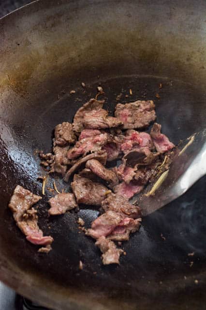 stir frying beef in a wok