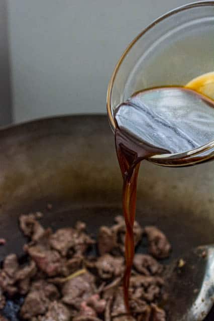 pouring sauce over mongolian beef