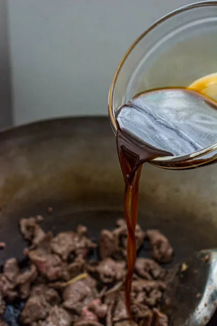 pouring sauce over mongolian beef