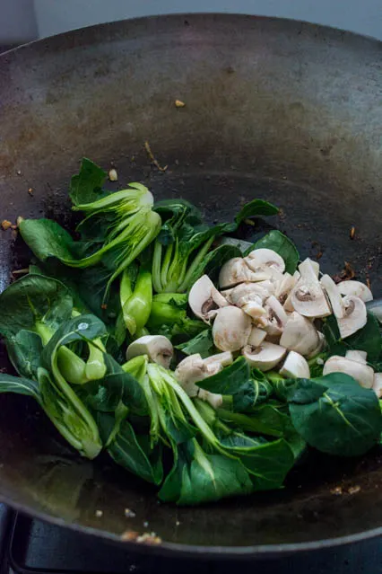 bok choy and mushrooms in wok