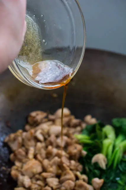 pouring sauce in stir-fry