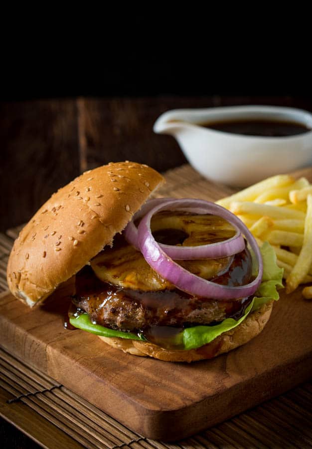 teriyaki burger with sliced red onion and pineapple