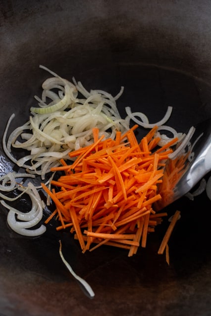 carrots and onion in a wok