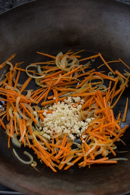 carrots, onions and garlic in a wok