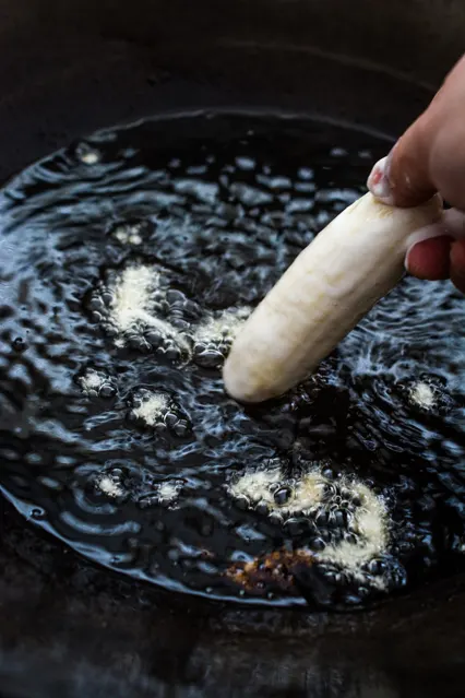 adding pisang goreng to hot oil