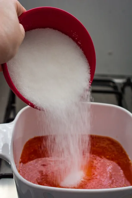 pouring sugar into sweet chili sauce
