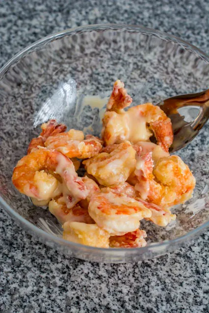 tossing shrimp in creamy honey sauce