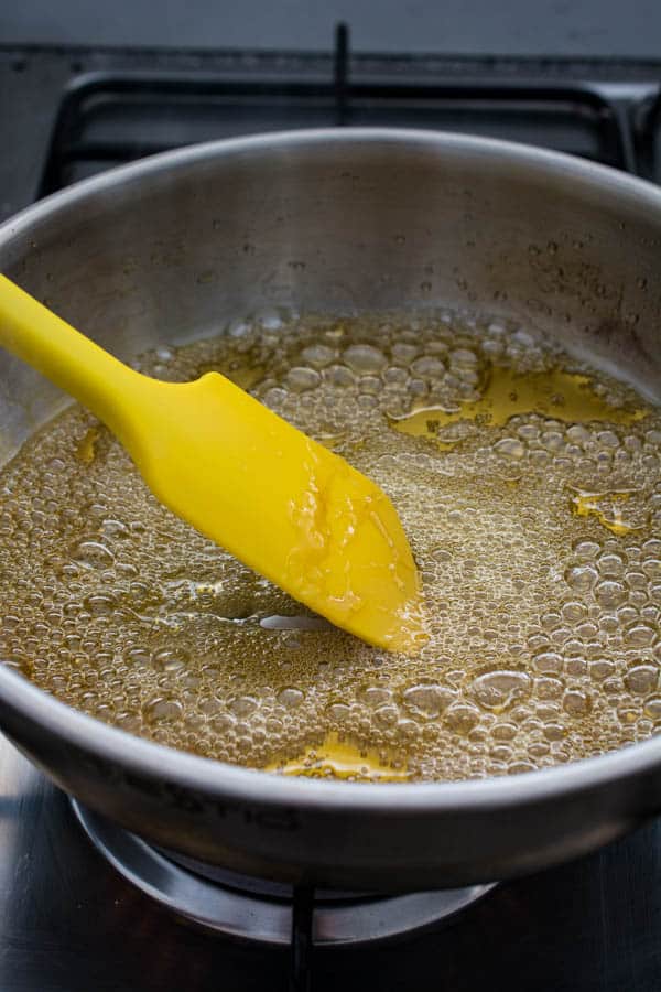 stirring caramel in saucepan with silicone spatula