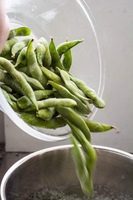 frozen edamame pods into boiling water