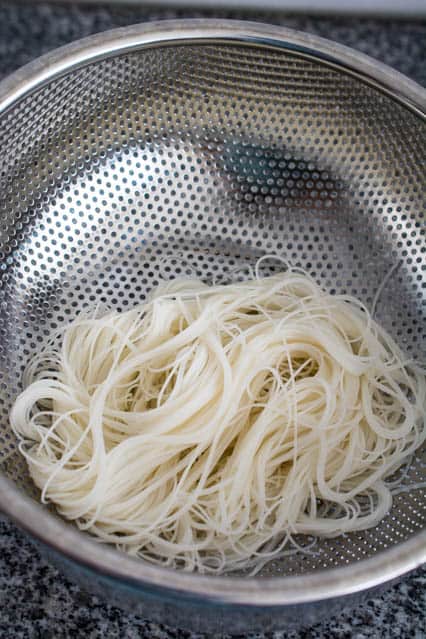 draining rice vermicelli noodles in colander.