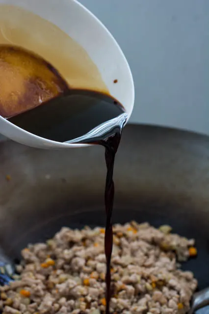 pouring sauce over ground pork for yuk sung