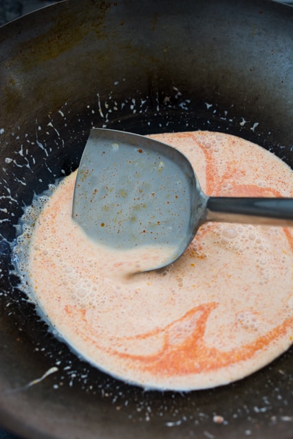 thai red curry with coconut milk in a wok