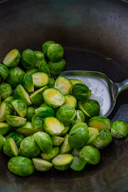 stir fried brussels sprouts in a wok