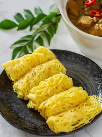 roti jala with a bowl of chicken curry