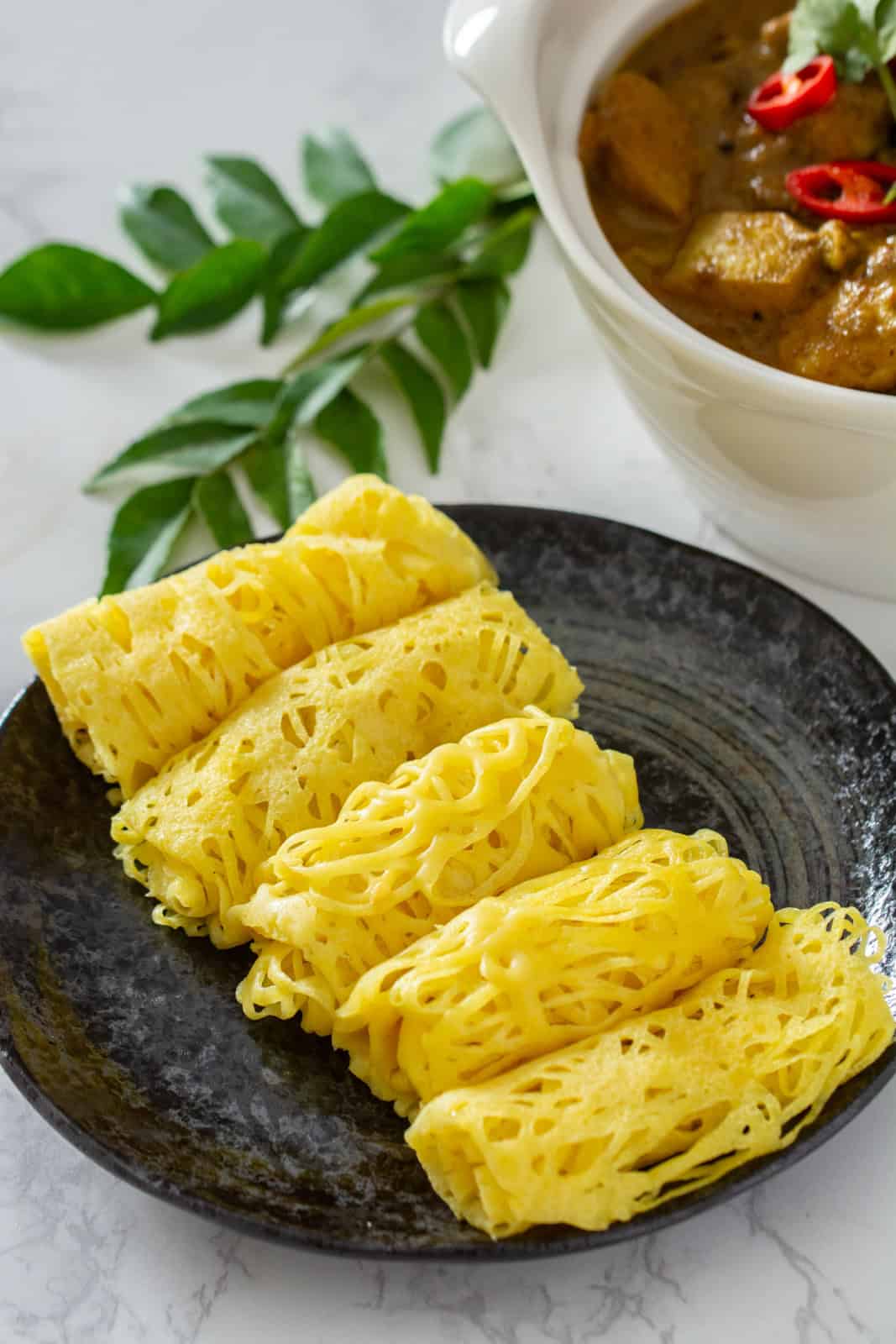 roti jala with a bowl of curry