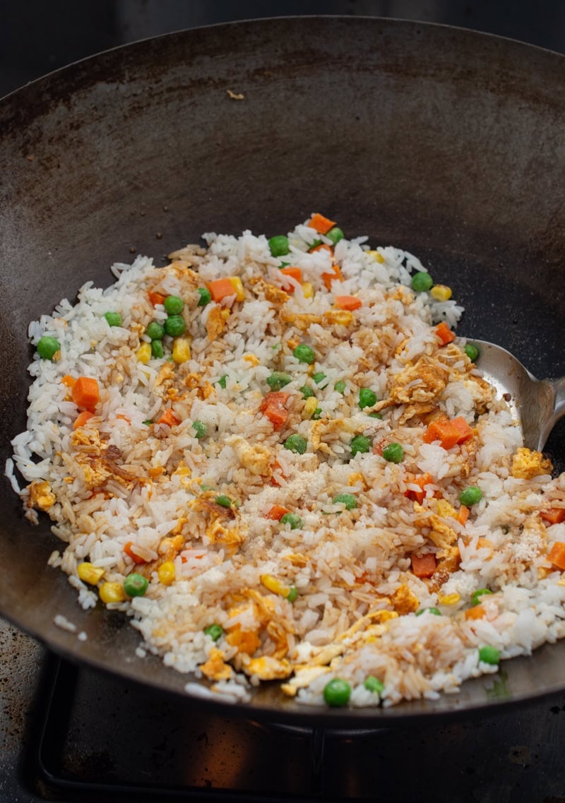 fried rice in a wok seasoned with soy sauce, white pepper and chicken bouillon