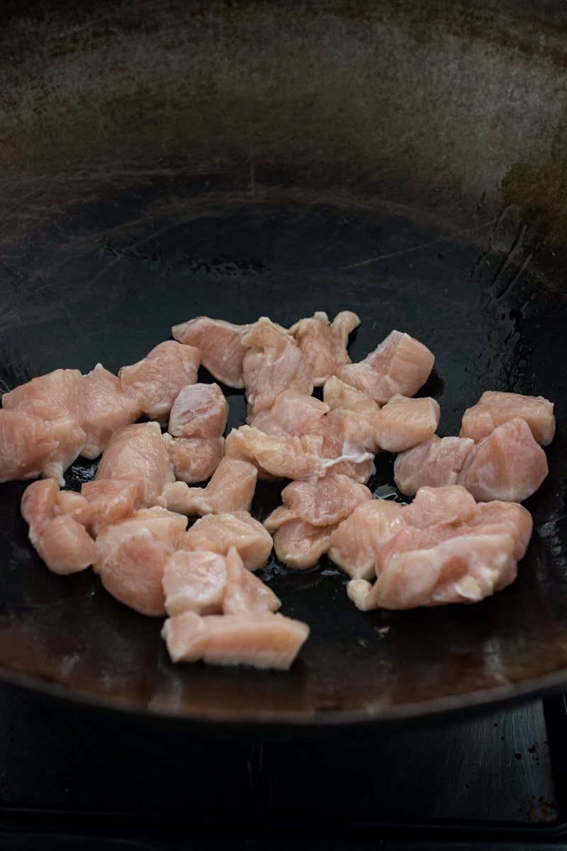 chicken in a single layer in a wok