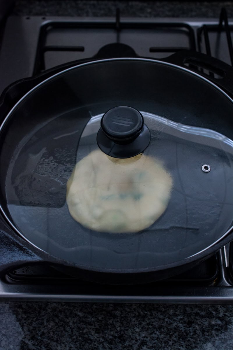 steaming chinese scallion pancake in a skillet