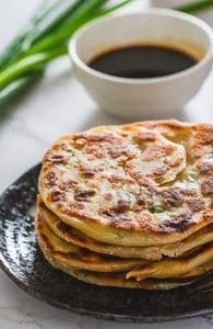 chinese scallion pancakes on a black plate