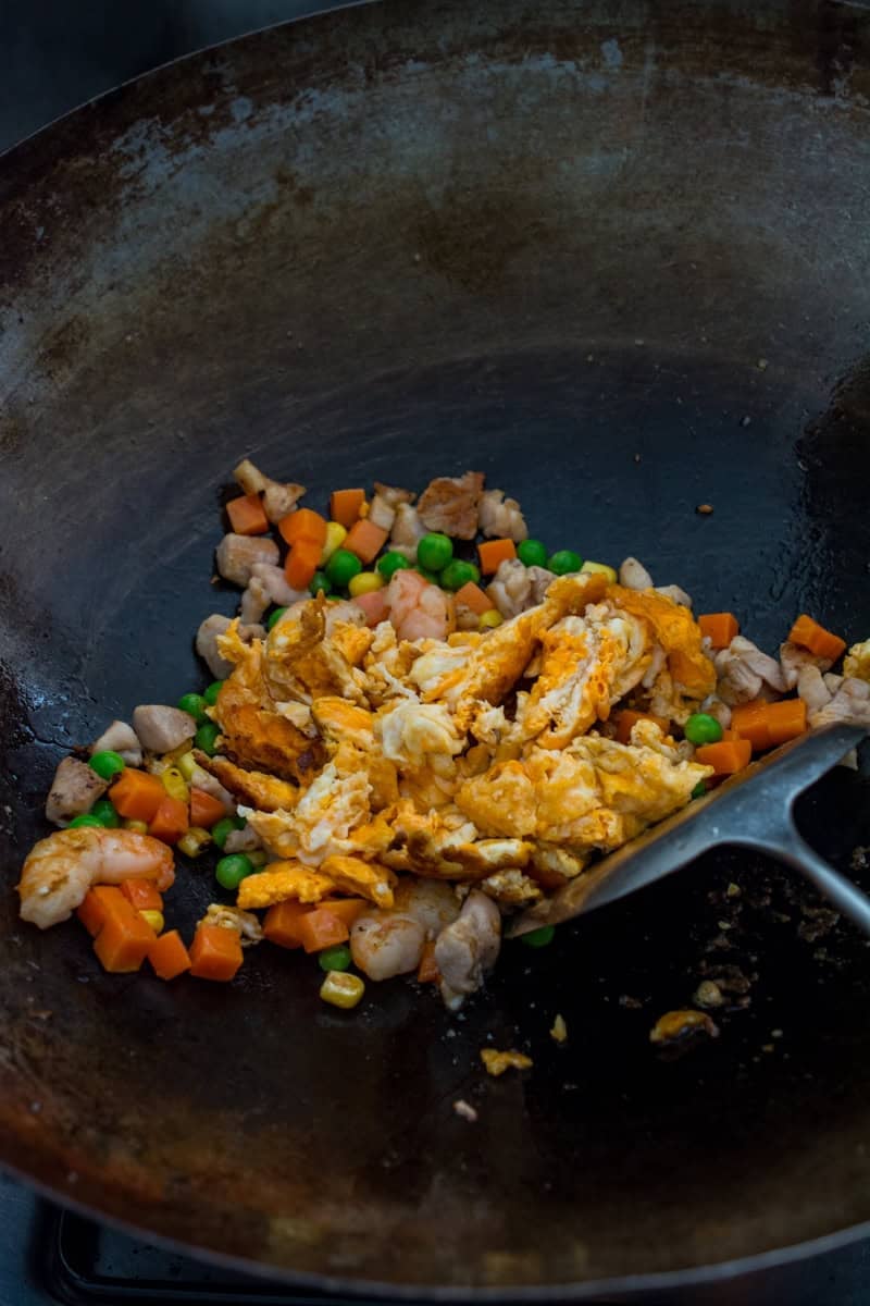 scrambled egg, mixed veggies, shrimp and pork in a wok
